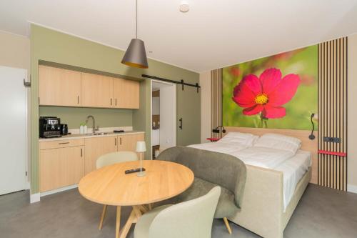 a bedroom with a bed and a table with a flower on the wall at Buitenplaats Hotel met terras, studio in Ellemeet