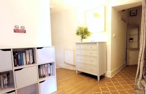 a room with a white dresser and a book shelf at Wigan Central Executive Apartments I Family Rooms I Free Parking in Wigan