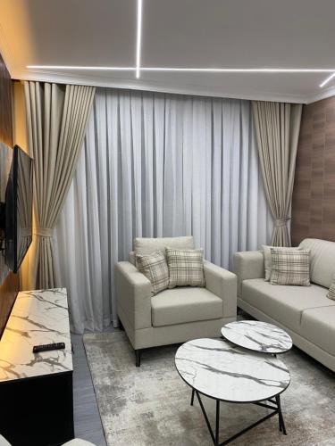 a living room with two couches and two tables at Swara Apartment, Block 1, Apartment A1 in Nanyuki