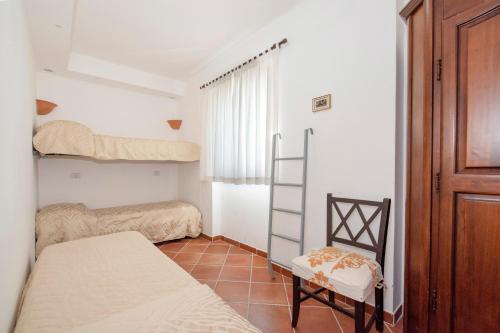a bedroom with two bunk beds and a chair at Wonderful villa with swimming pool overlooking the sea, 200 steps from the road in Conca dei Marini