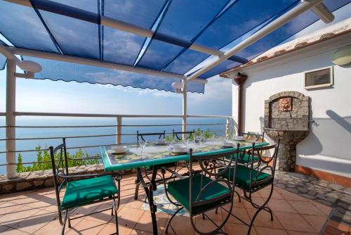 a patio with a table and chairs on a balcony at Wonderful villa with swimming pool overlooking the sea, 200 steps from the road in Conca dei Marini