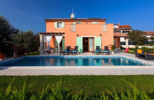 ein Haus mit einem Pool vor einem Haus in der Unterkunft Villas Vilanija in Umag