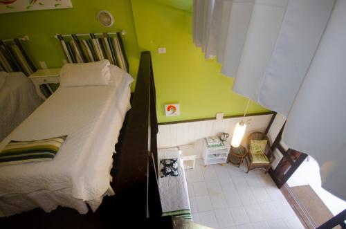 a bedroom with a bed and a green wall at Pousada Palmeiras Bombinhas in Bombinhas