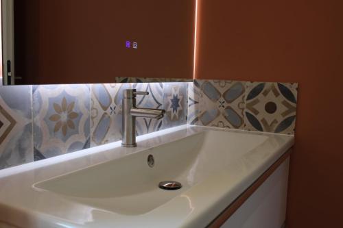 a white sink in a bathroom with a mirror at La Bullote - Gîtes - Paris Roissy CDG in Villeneuve-sous-Dammartin
