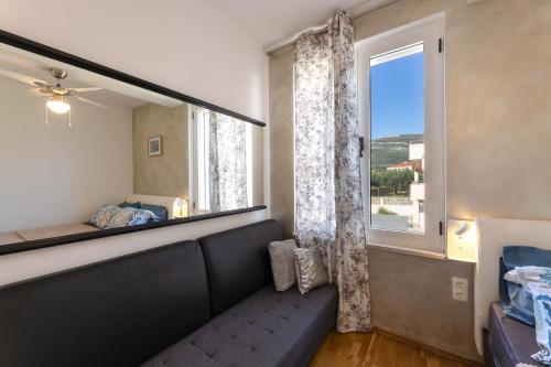 ein Wohnzimmer mit einer Couch und einem Fenster in der Unterkunft Apartmant with Pool 8 in Kaštela