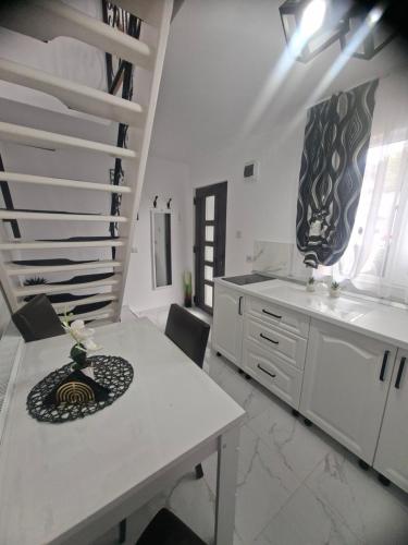 una grande cucina bianca con un tavolo e delle scale di Casuța Râului a Zărneşti