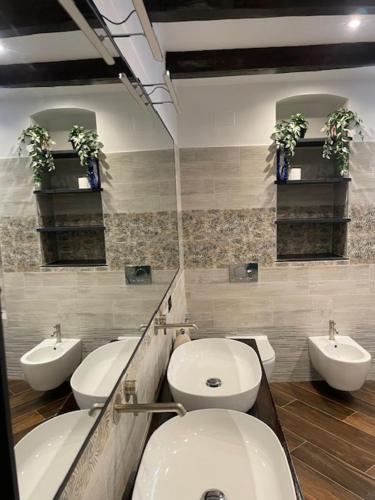 a bathroom with three sinks and a toilet and a mirror at Agriturismo S.Ilario in Genova