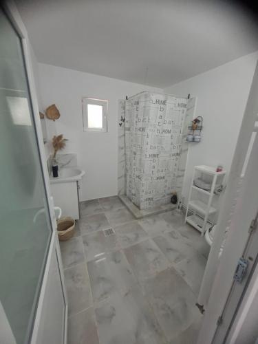 un bagno con doccia e pavimento piastrellato di Casuța Râului a Zărneşti