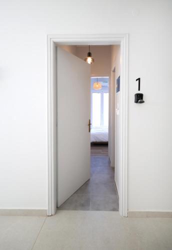 a hallway with a door leading to a bedroom at Muse Studios & Apartments Escape in Agia Marina Aegina