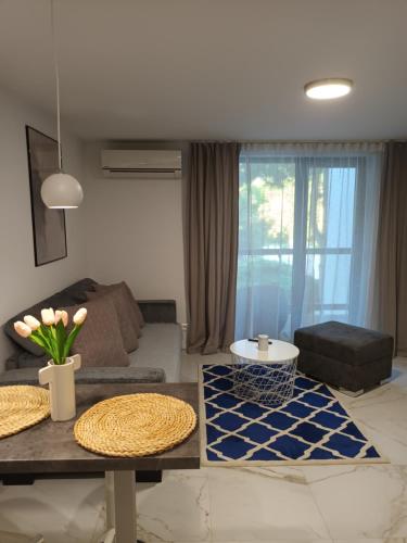 a living room with a couch and a table at Apartmán Sĺňava rezort Linea Piešťany in Piešťany
