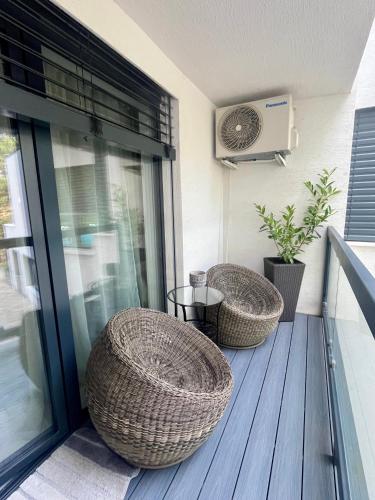 a porch with two wicker chairs and a fan at Apartmán Sĺňava rezort Linea Piešťany in Piešťany