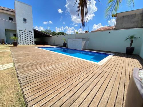 a backyard with a wooden deck and a swimming pool at Chácara Nova Aliança,Paulínia- São Paulo in Paulínia