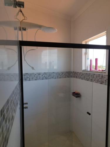 a shower with a glass door in a bathroom at Chácara Nova Aliança,Paulínia- São Paulo in Paulínia
