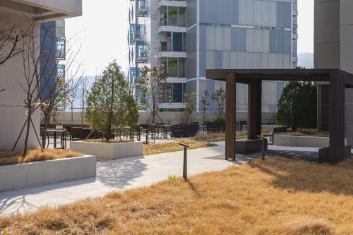 a park with tables and benches in a city at Mool Stay in Busan