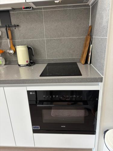 a kitchen with a black stove top oven in a kitchen at Mool Stay in Busan