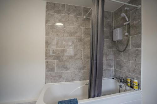 a bathroom with a shower and a bath tub at Cosy Home in Grimsby Town Centre in Grimsby