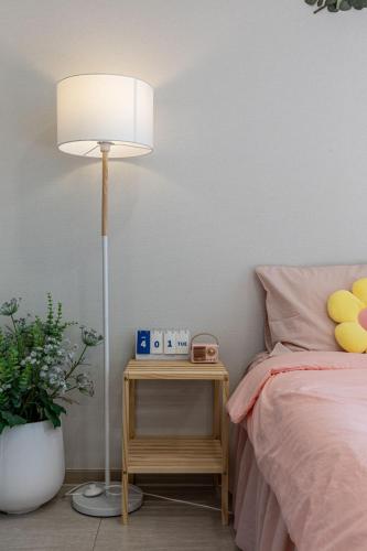 a bedroom with a bed and a table with a lamp at Mool Stay in Busan