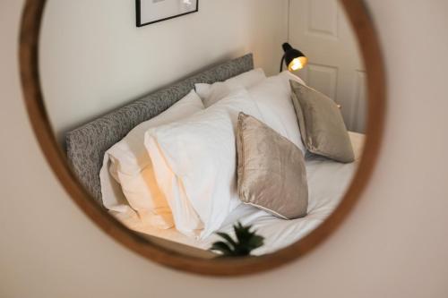 a mirror reflecting a bed with pillows on it at Cosy Home in Grimsby Town Centre in Grimsby