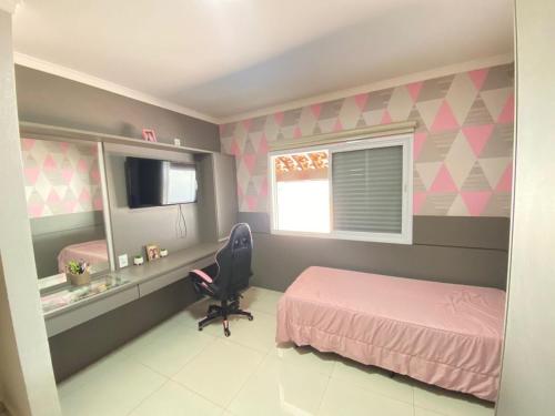 a bedroom with a pink bed and a chair at Chácara Nova Aliança,Paulínia- São Paulo in Paulínia