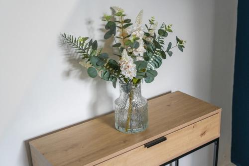 a vase of flowers sitting on top of a table at Cosy Home in Grimsby Town Centre in Grimsby