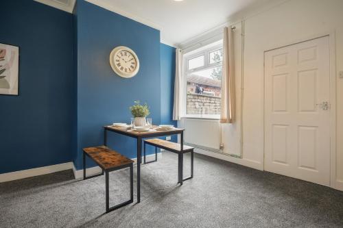 a blue room with a table and a window at Cosy Home in Grimsby Town Centre in Grimsby