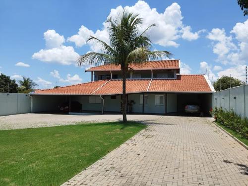 a house with a palm tree in the driveway at Chácara Nova Aliança,Paulínia- São Paulo in Paulínia