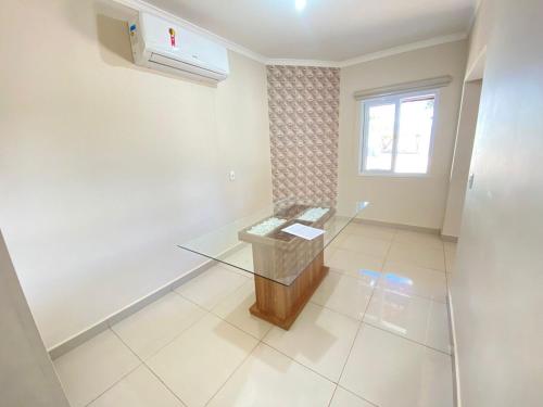 a room with a glass table and a window at Chácara Nova Aliança,Paulínia- São Paulo in Paulínia