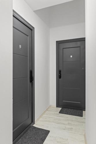 two black doors in a room with a tile floor at Selari Boutique in Bucharest
