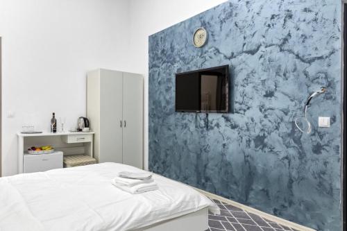a bedroom with a blue wall with a tv on it at Selari Boutique in Bucharest