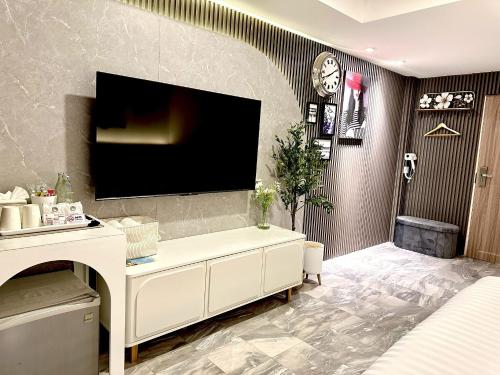 a living room with a tv on a wall at Dragon River Avenue in Phitsanulok