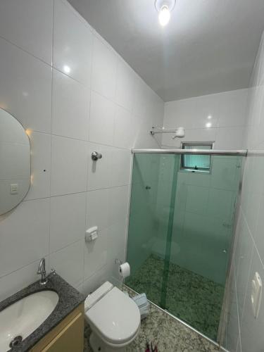 a bathroom with a shower and a toilet and a sink at Hostel Castelo in Belo Horizonte