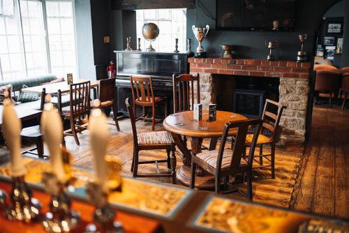 a restaurant with tables and chairs and a fireplace at The Rose & Crown, Ashbury in Ashbury