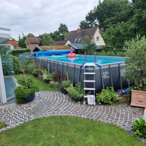 a swimming pool with a ladder in a yard at Ferienwohnung Aura in Bornhöved