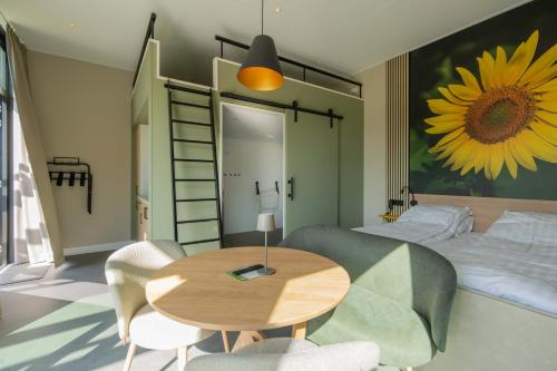 a bedroom with a table and a bed with a sunflower mural at Buitenplaats Hotel in Ellemeet