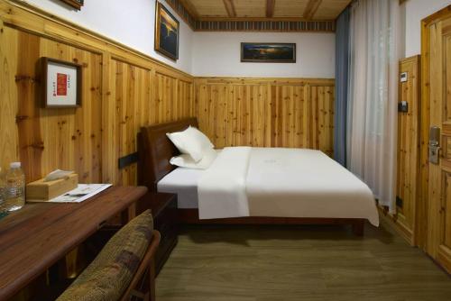 a bedroom with a bed and a wooden wall at Dream in Fenghuang in Fenghuang
