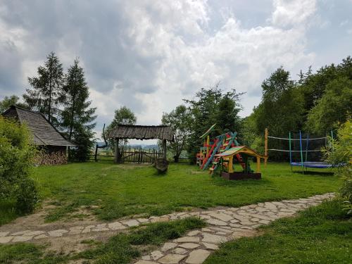 a park with a playground with a gazebo at Domki Osada Werdołyna in Polańczyk