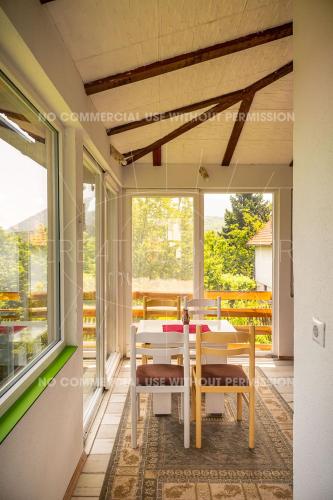 a dining room with a table and chairs on a porch at Cottage Eminem with garden and view of Sarajevo in Hadžići