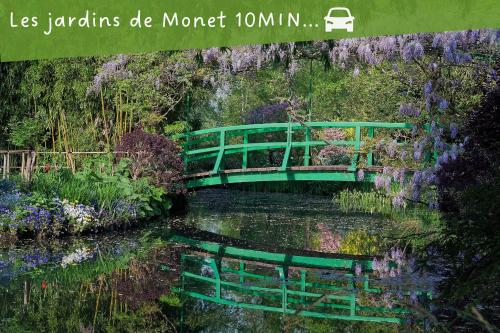a green bridge over a river with flowers at La Suite des Rêves - Les Bonn'apparts-Sur-Seine in Bonnières-sur-Seine