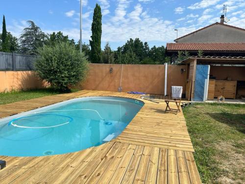 a backyard with a pool and a wooden deck at La maison de Claude avec terrasse et piscine in Crest