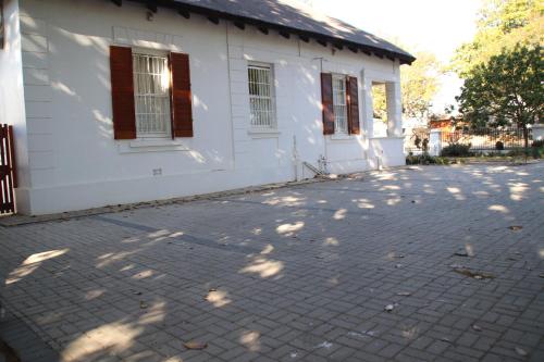 a white house with a brick driveway in front of it at Petal's Place in Robertson