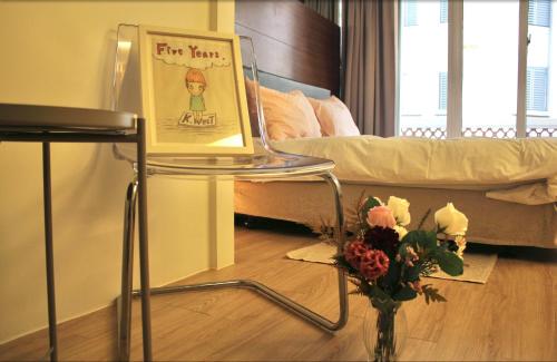 a sign on a chair with a vase of flowers at 喃行旅-一房一車位 毛孩友善客房數量有限請先預約 in Tainan