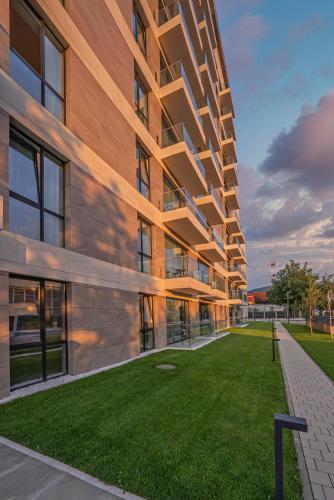 an exterior view of a building with a green lawn at ONE66 - Luxury Aparthotel in Braşov