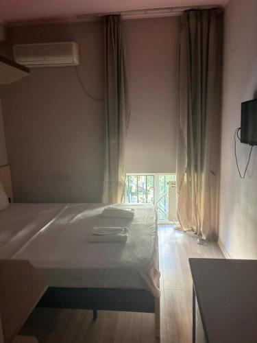 a bedroom with a white bed and a window at Boutique Hotel Taste Tbilisi in Tbilisi City