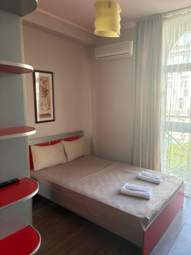 a bedroom with a bed in a room with a window at Boutique Hotel Taste Tbilisi in Tbilisi City