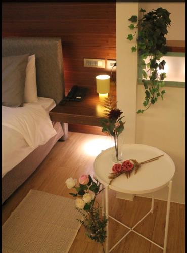 a room with a bed and a table with flowers on it at 喃行旅-一房一車位 毛孩友善客房數量有限請先預約 in Tainan