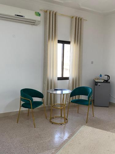 two chairs and a table in a room at Arabian Nights Nook in Muscat