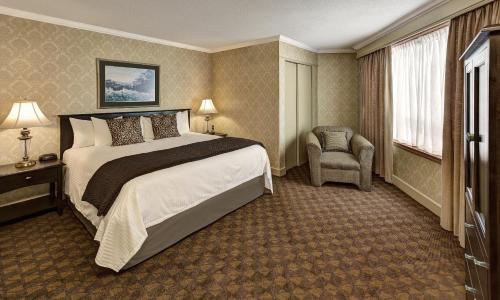 a hotel room with a large bed and a chair at The Water Tower Inn - BW Premier Collection in Sault Ste. Marie