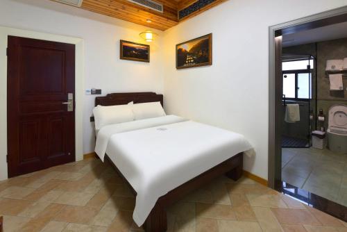 a bedroom with a white bed in a room at Dream in Fenghuang in Fenghuang