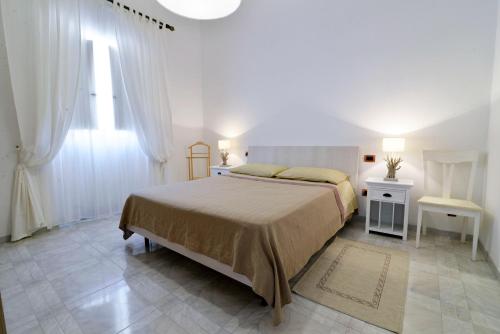 ポリニャーノ・ア・マーレにあるAffittacamere A Pochi Passiのベッドルーム1室(ベッド1台、テーブル2台、窓付)
