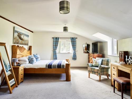 un dormitorio con una cama y una silla en Bedlwyncoch Farmhouse, en Brecon